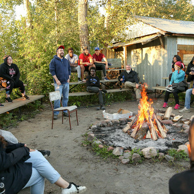 The Residence Coordinator and students around a campfire.