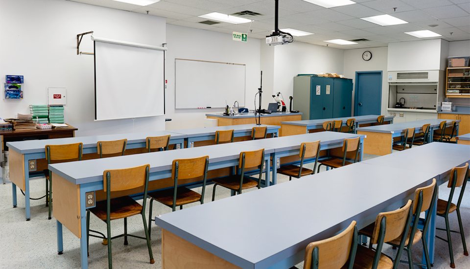 Work tables oriented toward a white board and projection screen.