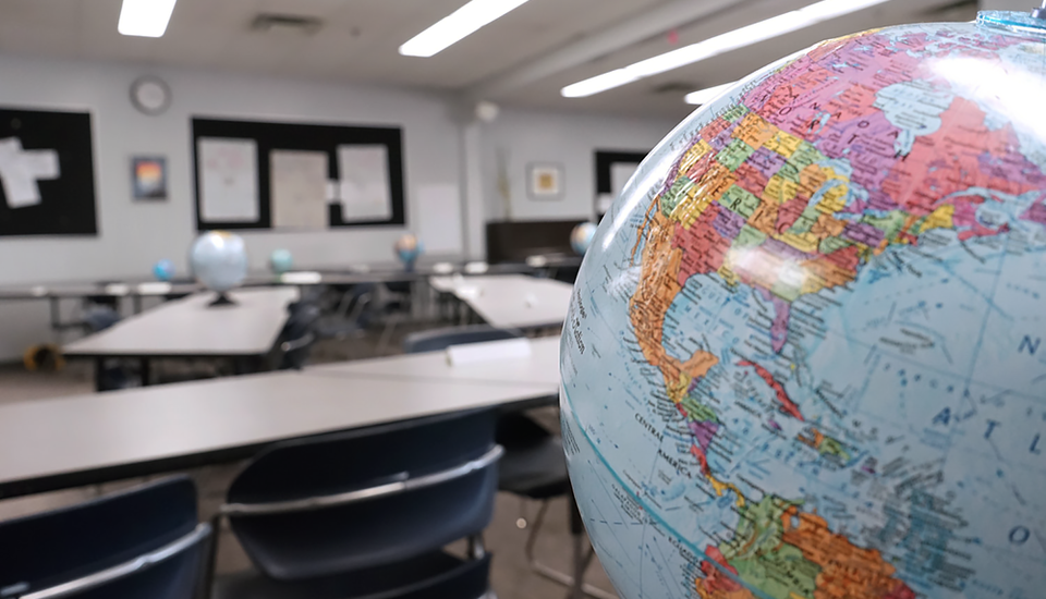 Globe in the foreground, tables for different work space in background.