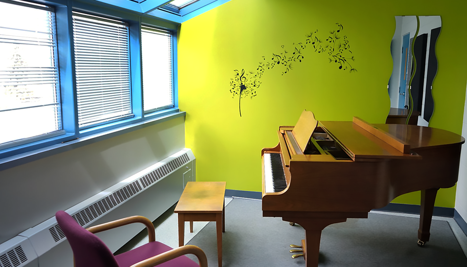 Brightly colored walls, large windows, and a grand piano.