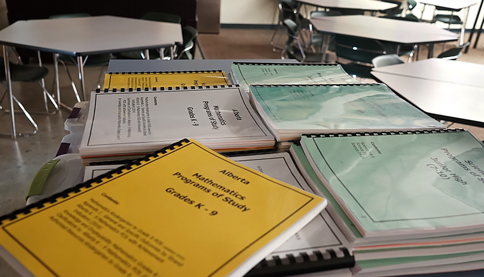 Pile of Alberta curriculum booklets.