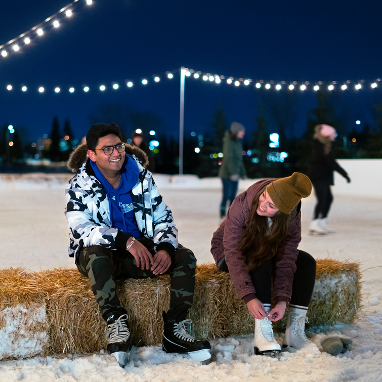 Students tying their skates at the outdoor ice skating rink