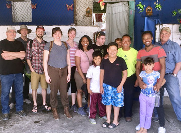 deKoning (third from the left) with the Quest group, Justino (a third-generation resident of an urban squatter settlement), and his family. Residents are regularly threatened with jail time or expulsion from their homes as a result of not having ownership