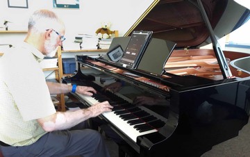 Segger demonstrating the piano's features as he plays.
