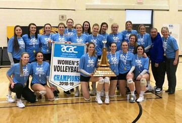Eagles women’s volleyball team with their championship banner
